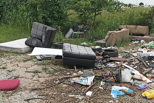 unauthorized dump site with abandoned furniture